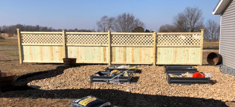 Completed privacy fence behind garden patio space in side yard