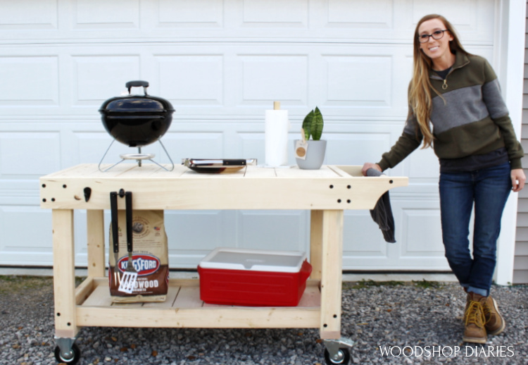 Shara holding onto handle of mobile DIY grill cart with portable grill on top and cooler on bottom