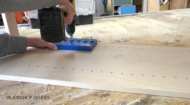 Using a shelf pin jig to drill shelf pin holes into cabinet sides