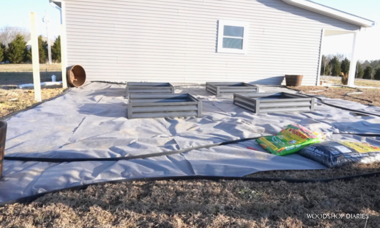 Backyard makeover with mesh laid down and raised garden beds in place