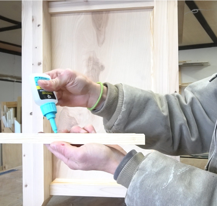 Shara using RapidFuse to attach trim pieces to side of DIY file cabinet