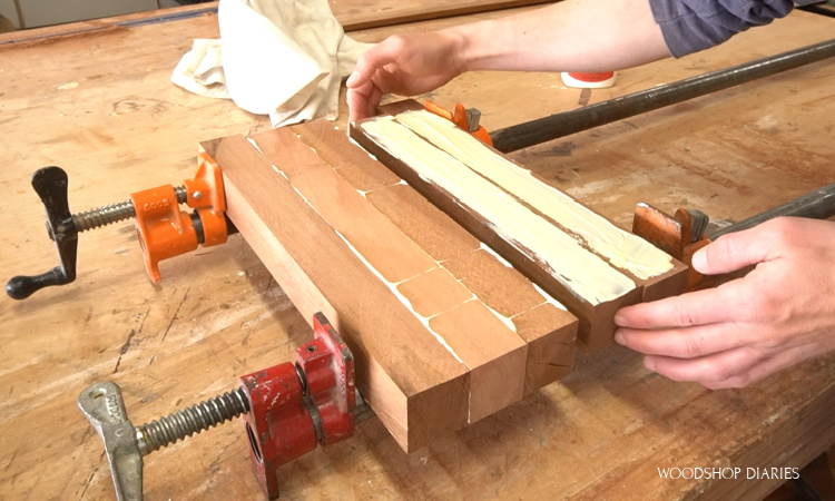 Gluing up section of cutting board in pipe clamps with wood glue