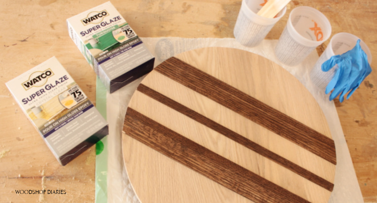 Supplies needed for resin and wood lazy susan--super glaze epoxy and red oak circle laid out on workbench