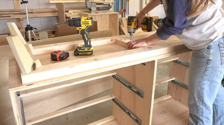 Shara Woodshop Diaries screwing base frame into bottom of dresser box