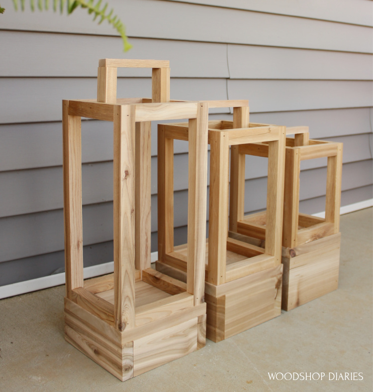 DIY outdoor scrap wood lanterns in three sizes on front porch