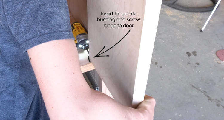 Installing bottom hinge onto door from inside of armoire wardrobe cabinet