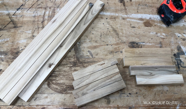 Pieces cut and laid out on workbench to assemble scrap wood lantern frame