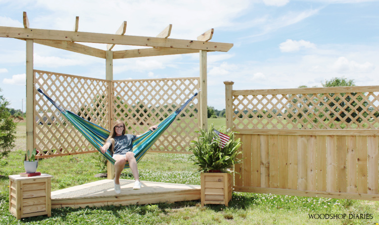 Shara Woodshop Diaries sitting in hammock on hammock stand with pergola