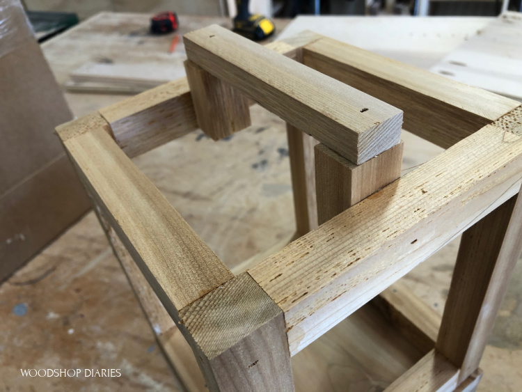 Close up of scrap wood handle glued and nailed to top of lantern frame