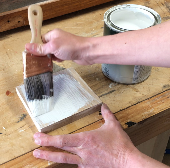 applying finish coat to filled wood grain with paint brush