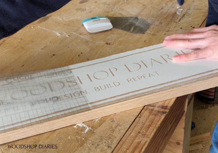 Remove transfer tape from vinyl stencil on oak board