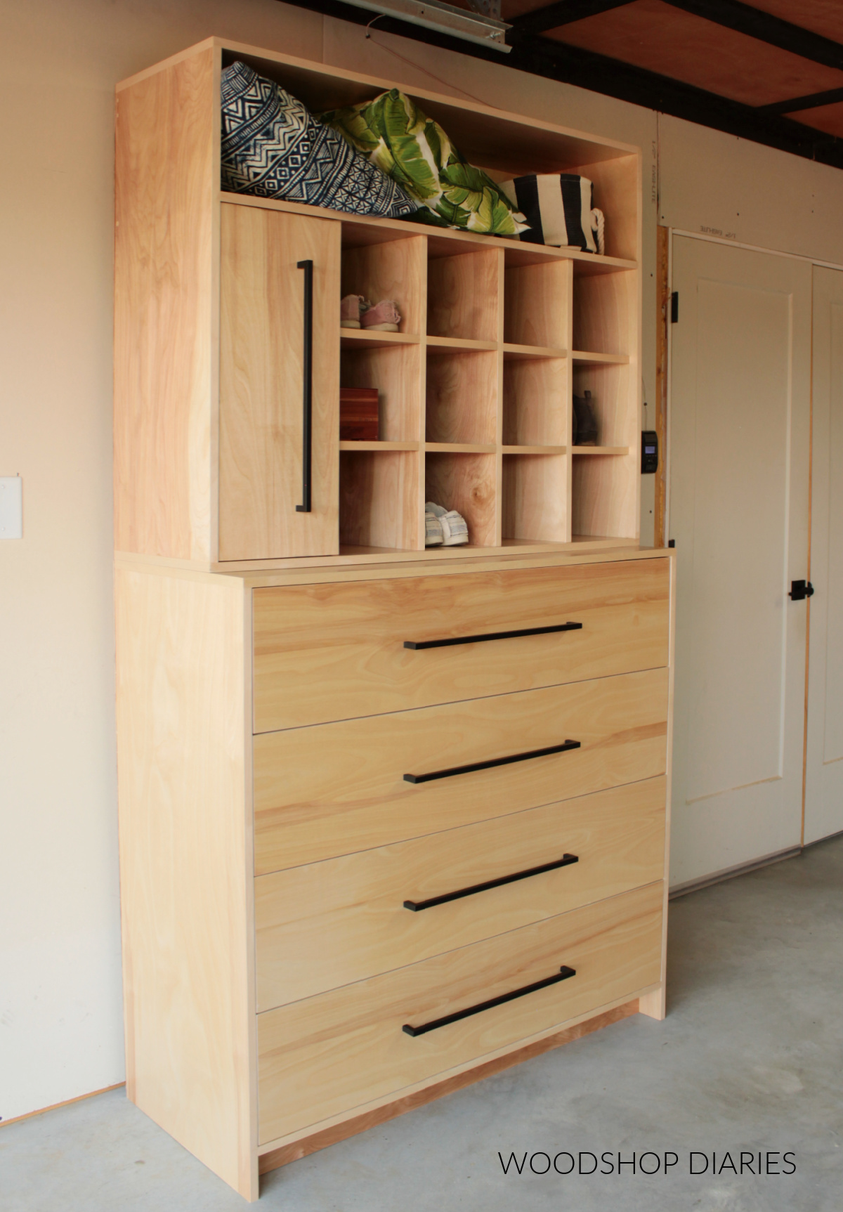 Finished plywood DIY Closet system with dresser on bottom and shoe cubbies and shelving on top.