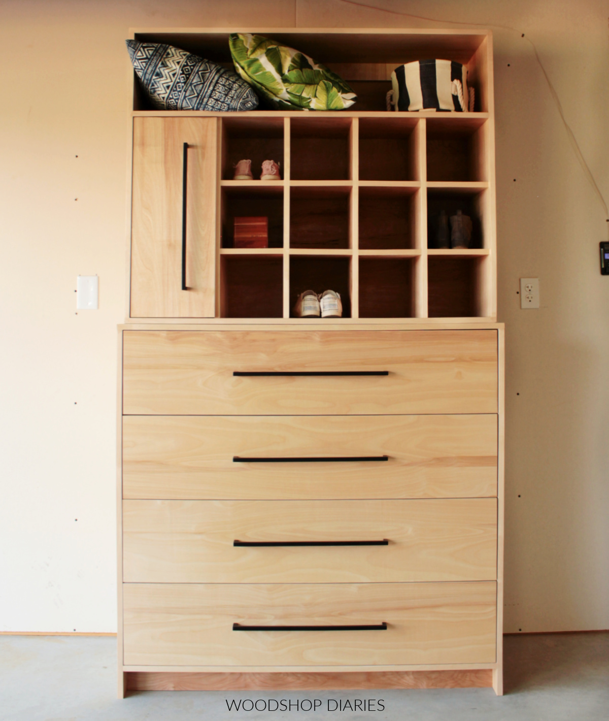 DIY plywood closet cabinet system with long shelf at top, large drawers on bottom and shoe cubbies
