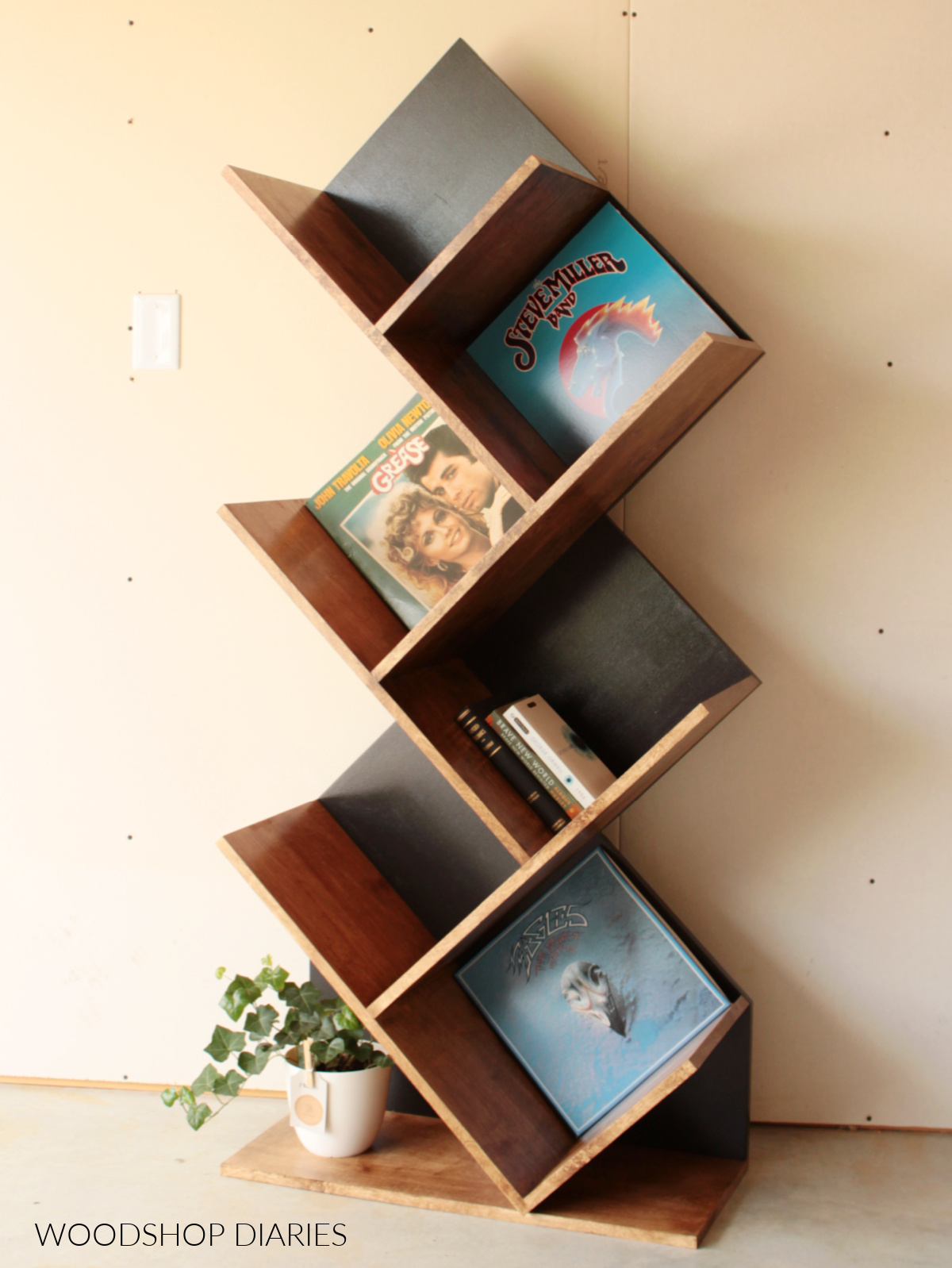 Black and wood modern, tilted DIY vinyl record album display shelf against gray wall