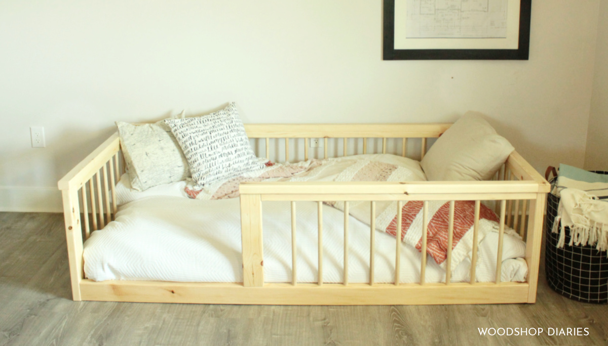 Simple pine floor bed frame sitting on floor completed