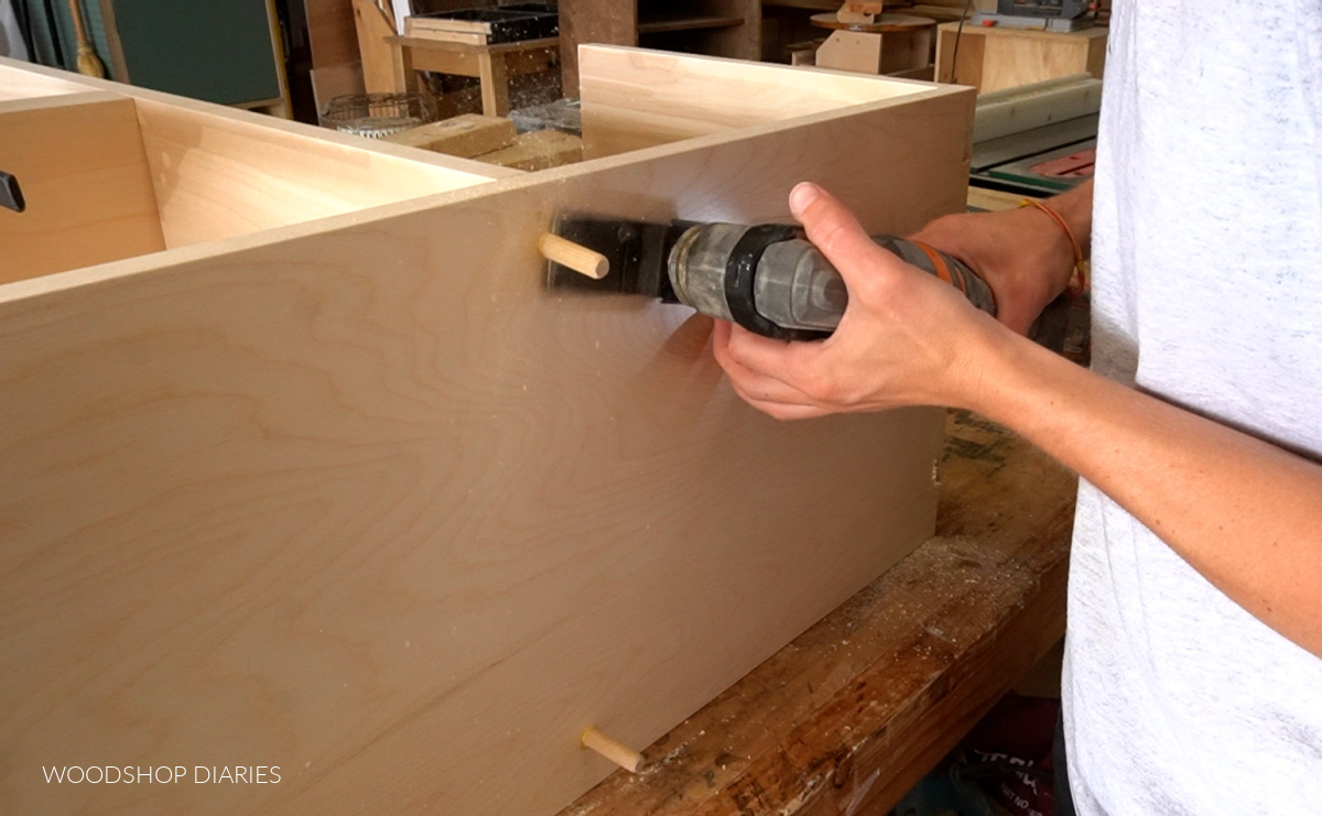 Shara using Ridgid oscillating tool to flush cut dowel plugs in screws holes