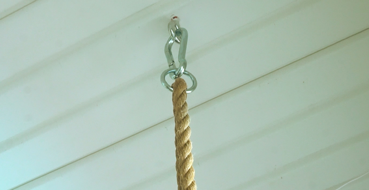 Close up of eye screws and carabiner clips used to hang DIY porch swing bed