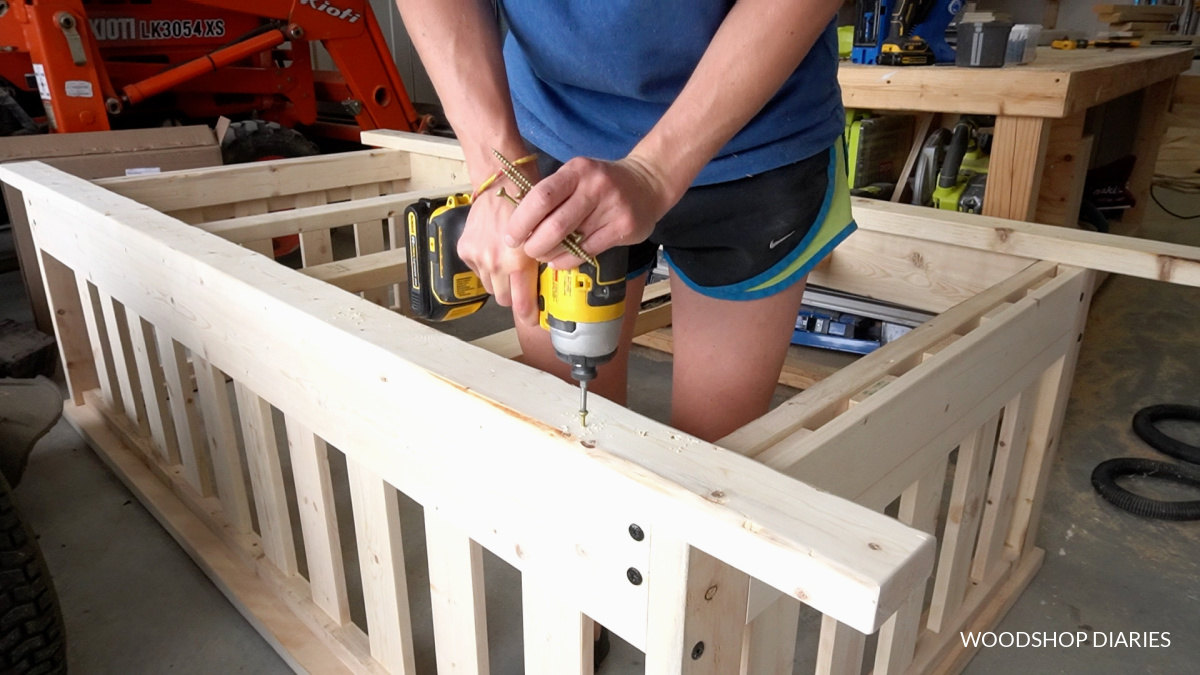 Shara installing bottom runners along front and back of swing frame using screws