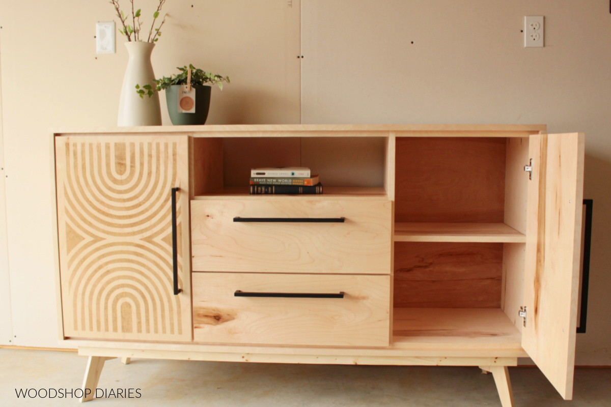 Finished DIY mid century modern dresser console with stenciled door open to show adjustable shelf