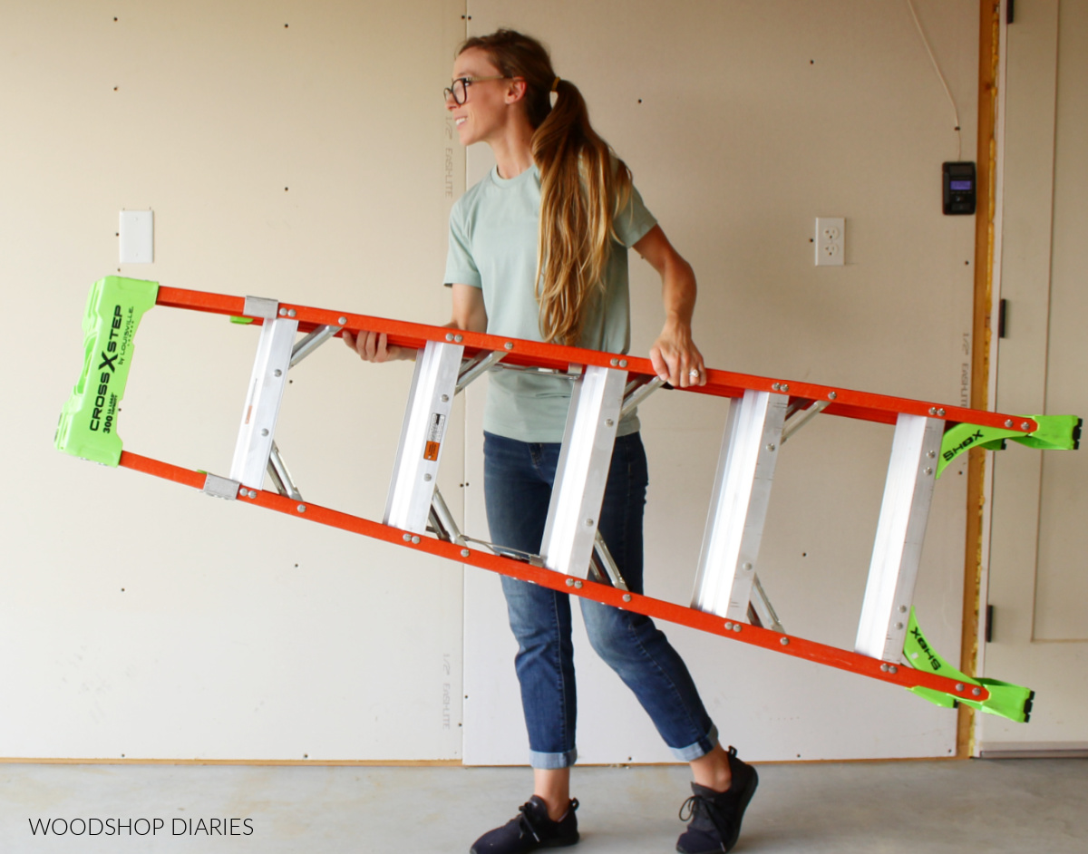 Shara Woodshop Diaries carrying Louisville ladder cross step in garage showing lightweight