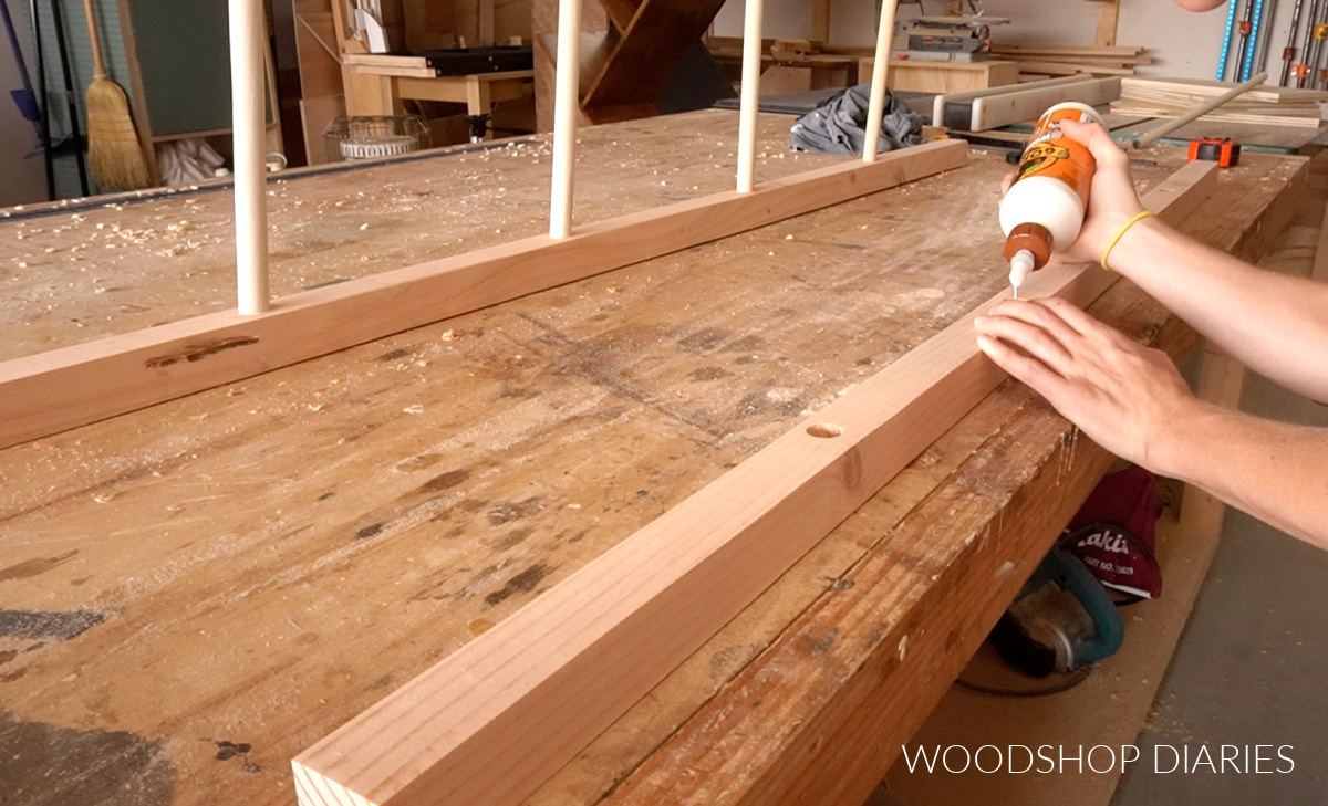 Shara applying wood glue into holes on 2x2 blanket ladder sides