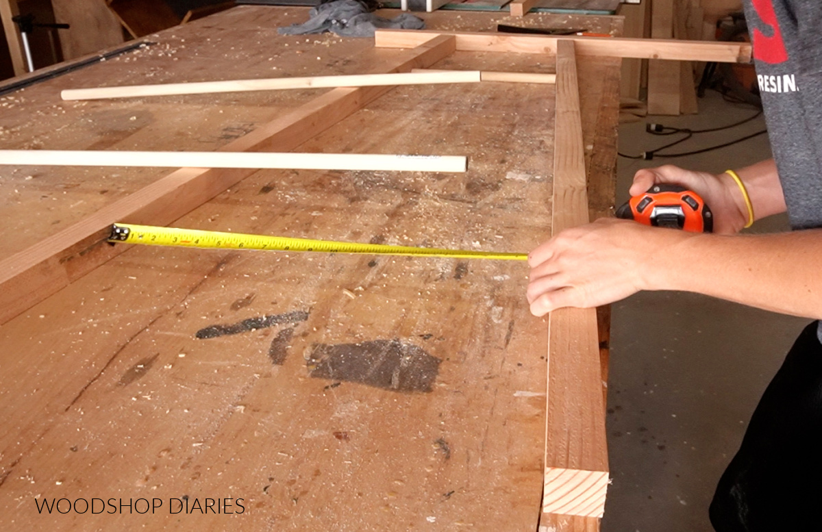 Shara measuring dowel lengths on tapered wooden blanket ladder 