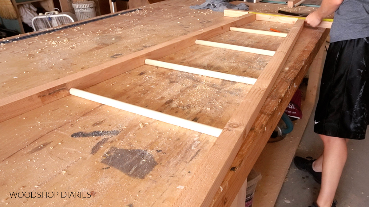 Blanket ladder 2x2s and rungs laid out on workbench to test fit