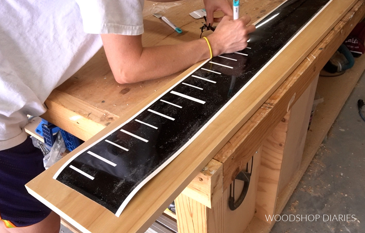 Shara removing the ruler marks from the vinyl