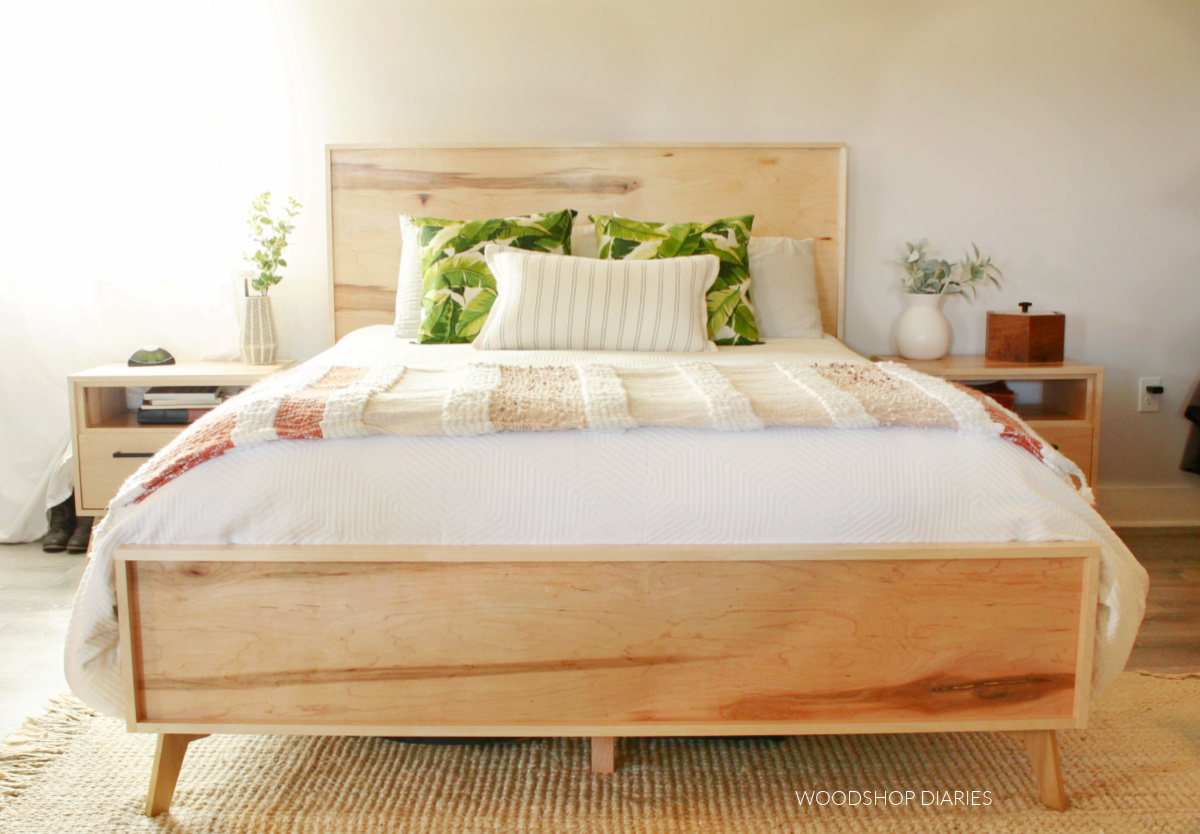 Finished plywood mid century modern bed with white comforter and matching nightstands