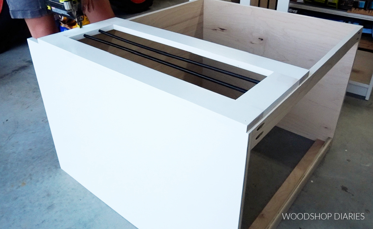 Shara Woodshop Diaries brad nailing face frame onto wooden dog crate cabinet