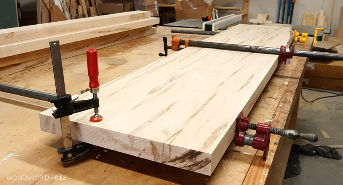 Two maple boards being glued together on workbench to make dining table top