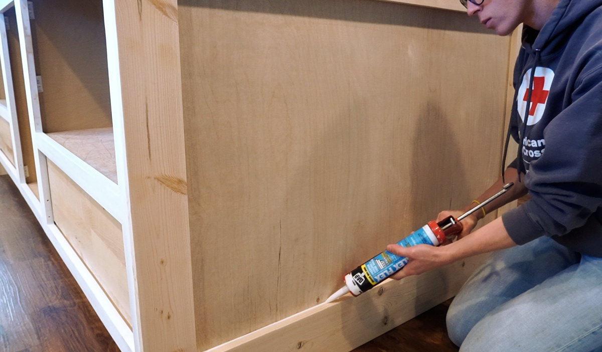 Shara Woodshop Diaries using DAP Alex Flex Caulk to caulk inside corners of kitchen island trim