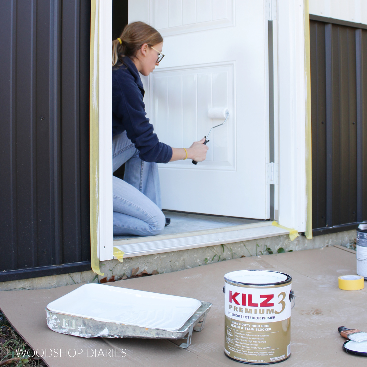 Shara Woodshop Diaries using paint roller to roll primer on door