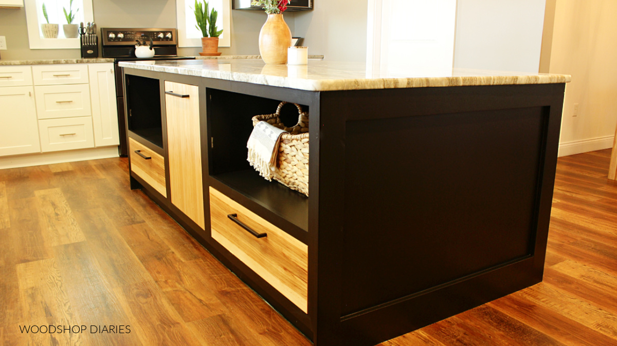 Black kitchen island in white kitchen with hickory door and drawer fronts