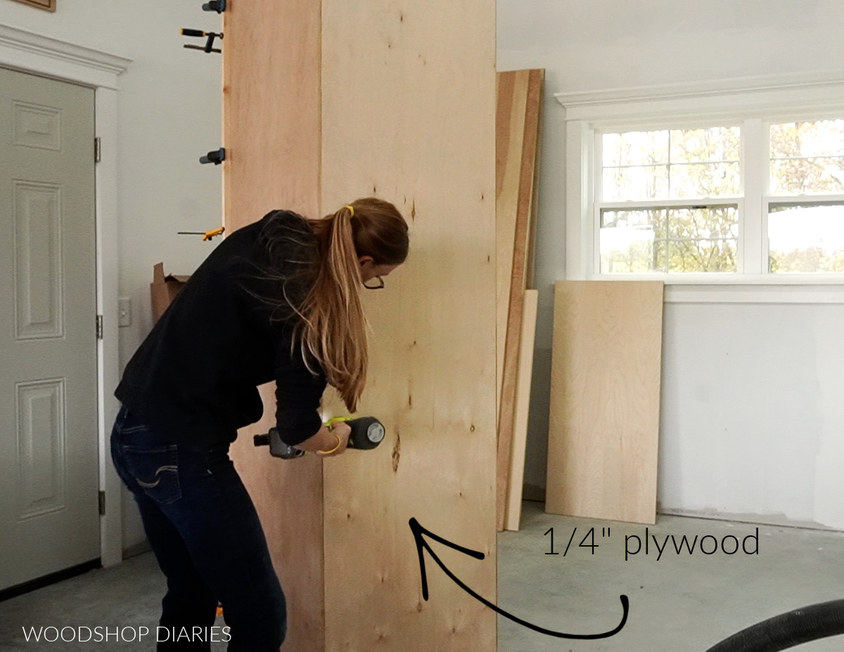 Shara Woodshop Diaries stapling ¼" plywood backer onto pantry cabinet