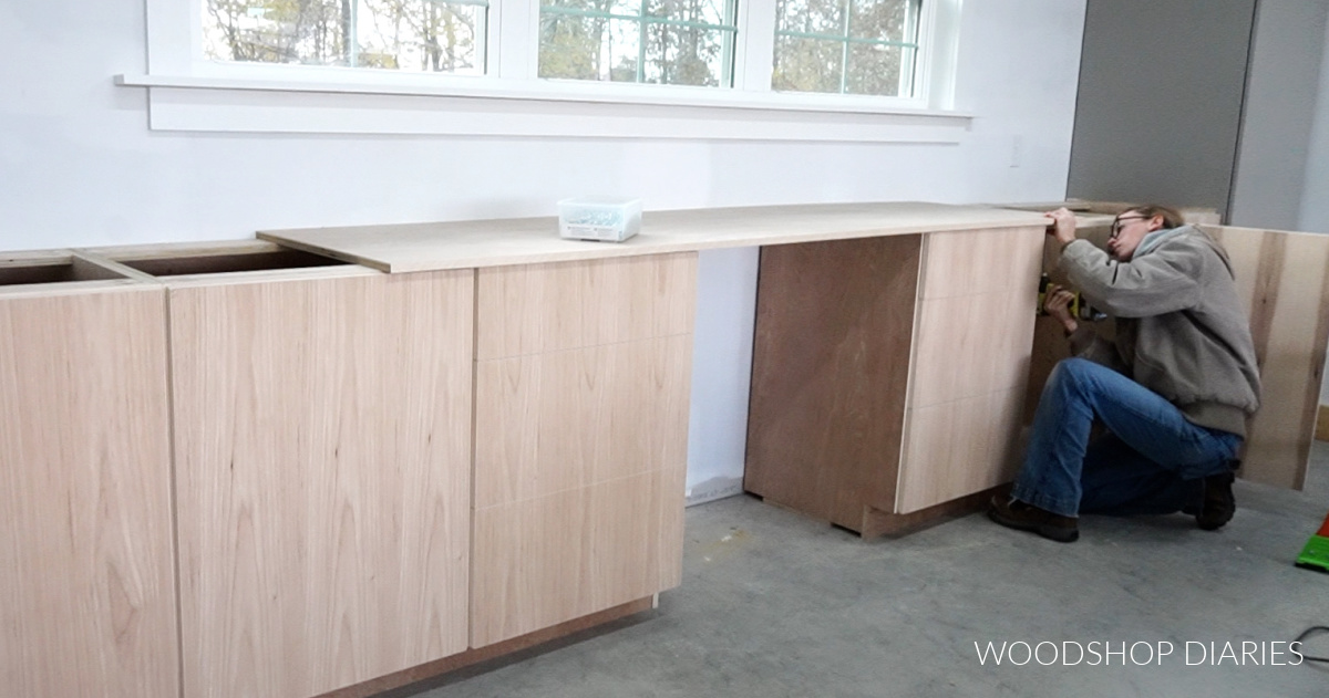 Shara installing countertop through top supports of cabinet boxes