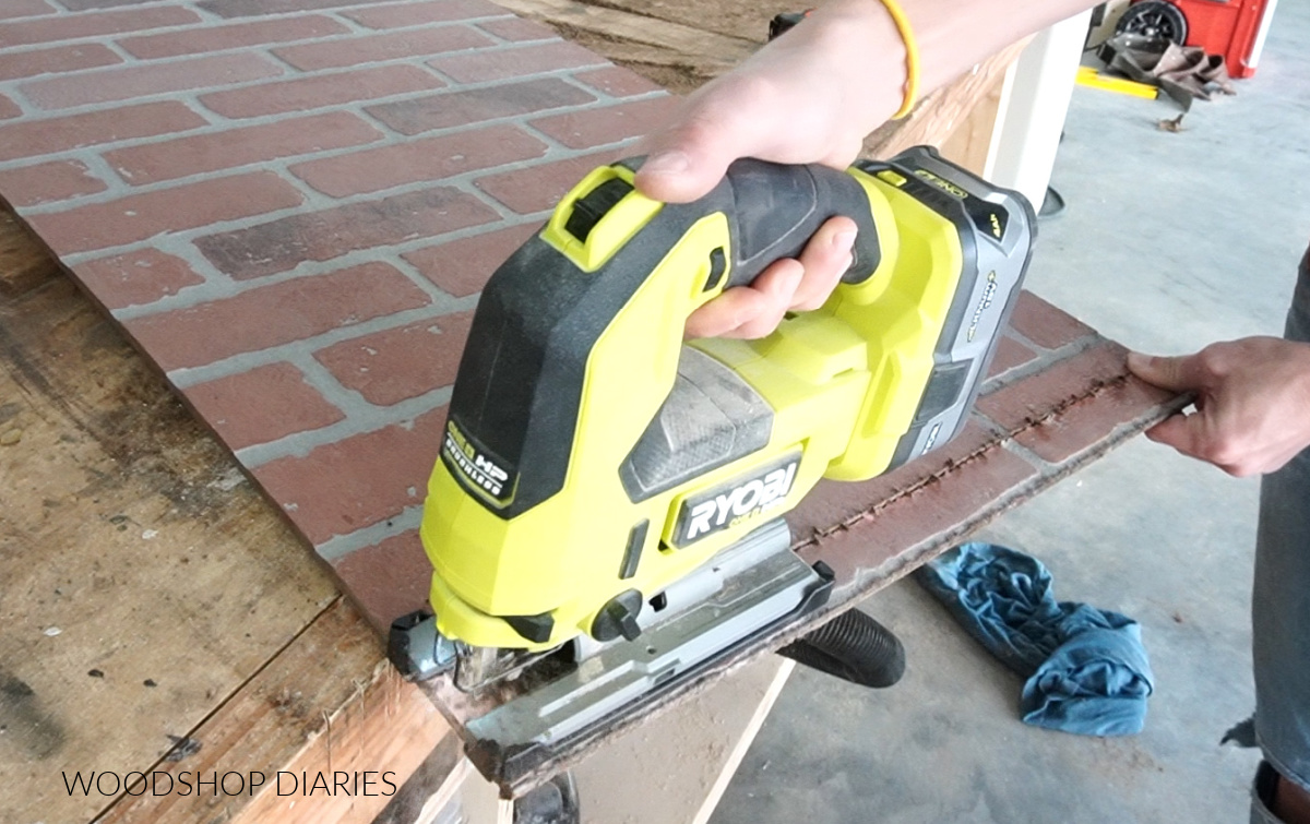 Close up of jig saw trimming end of brick panel