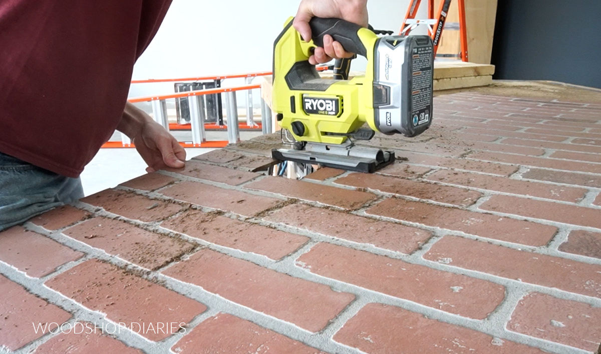 Shara Woodshop Diaries using jig saw to cut out outlet holes in brick panel