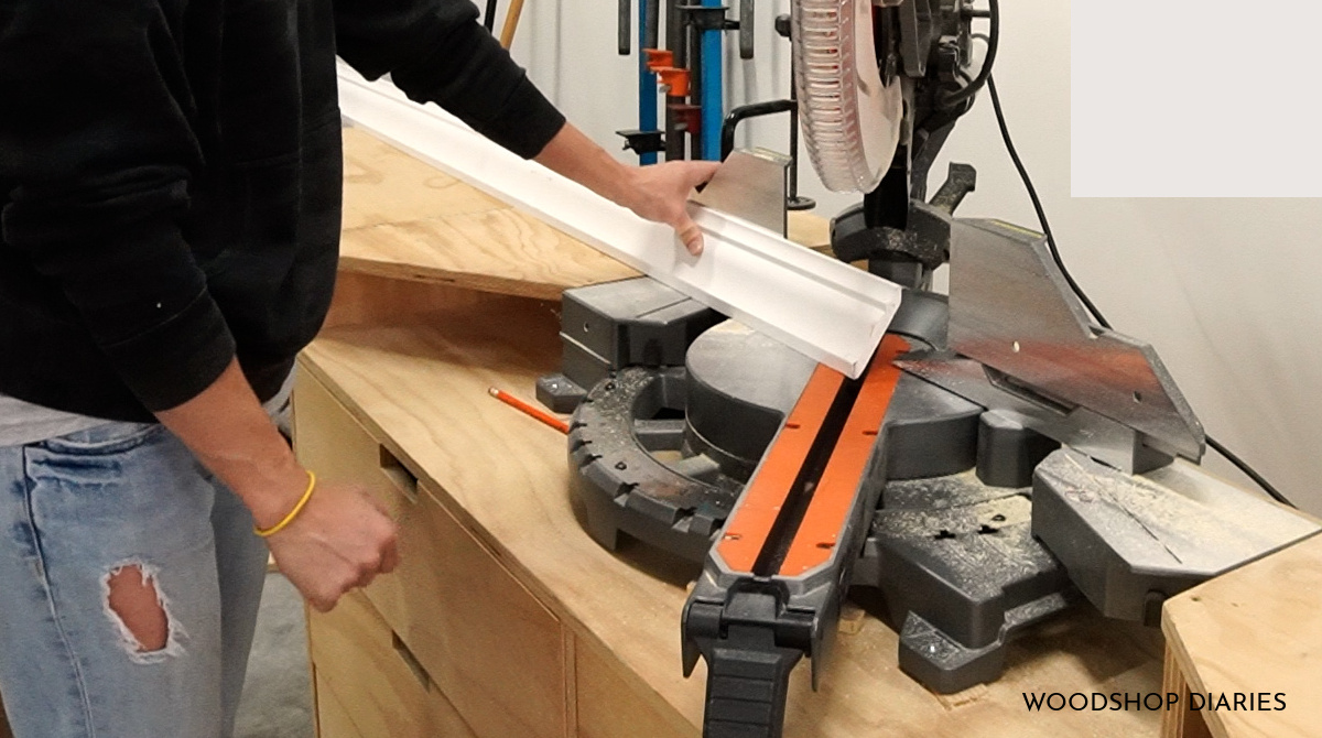 Shara Woodshop Diaries holding crown molding in miter saw upside down