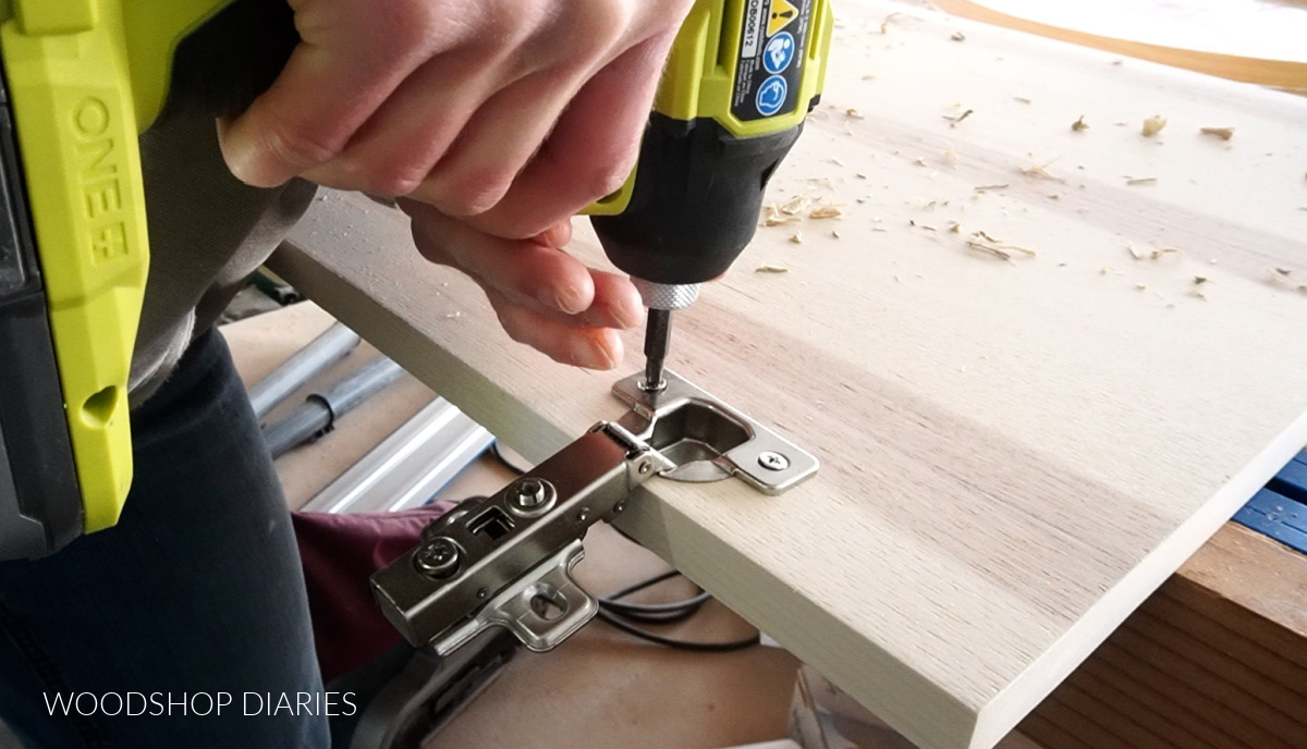 Close up installing concealed hinge onto plywood cabinet door
