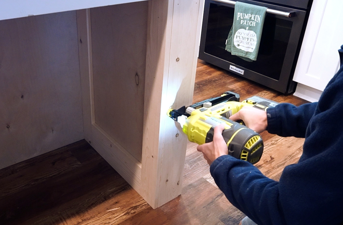 Using a finish nailer to nail front pieces onto kitchen island legs