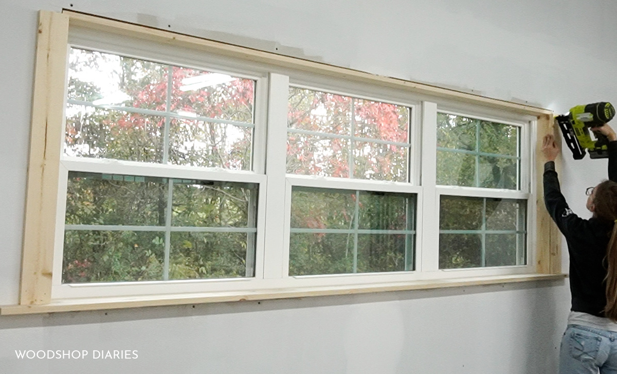 Shara Woodshop Diaries nailing side boards on left and right of window to frame it out