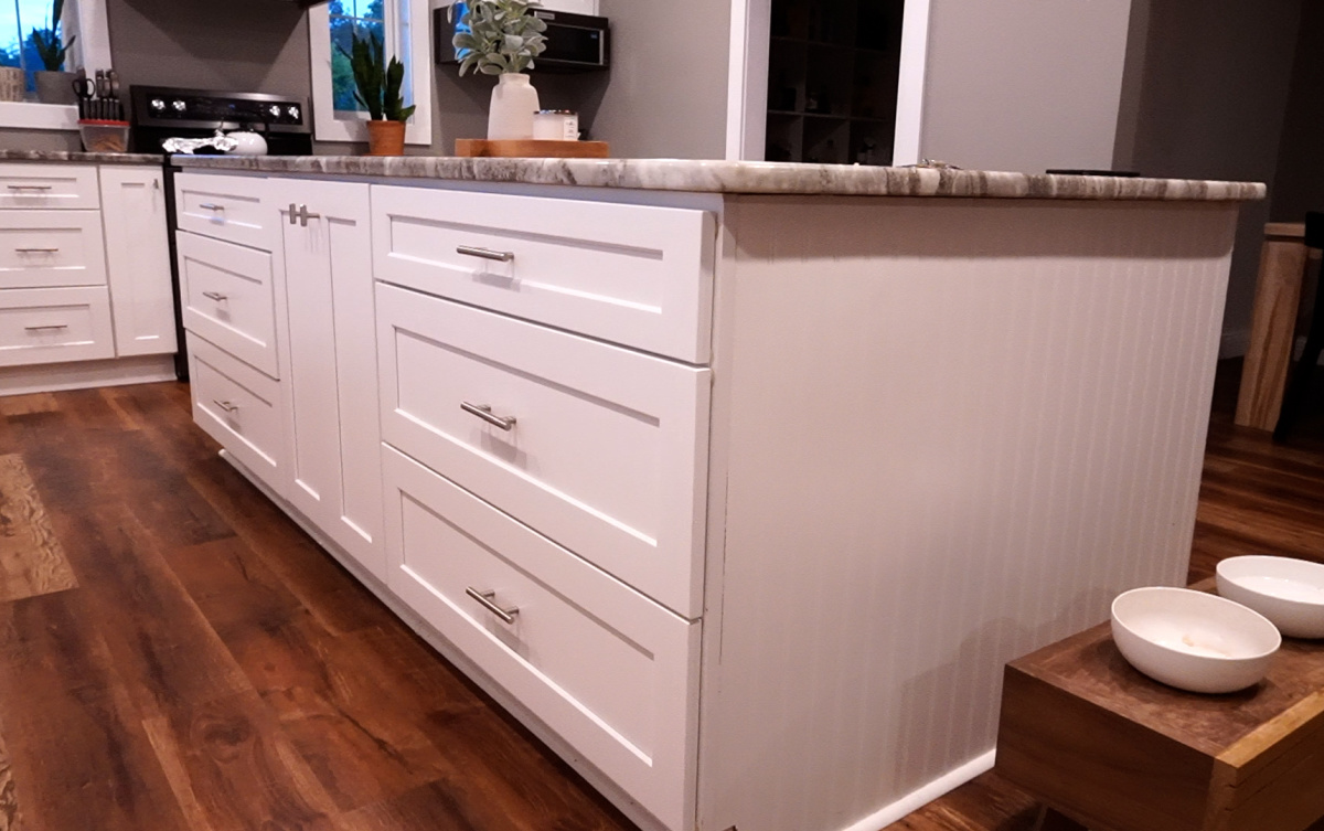 White kitchen island with beadboard sides, 6 drawers, and a door cabinet