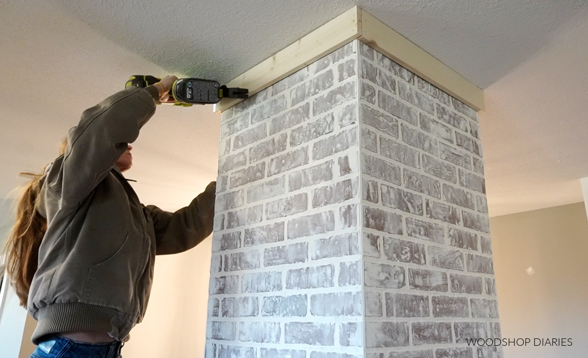 Shara using nail gun to install 1x5 trim around top of column