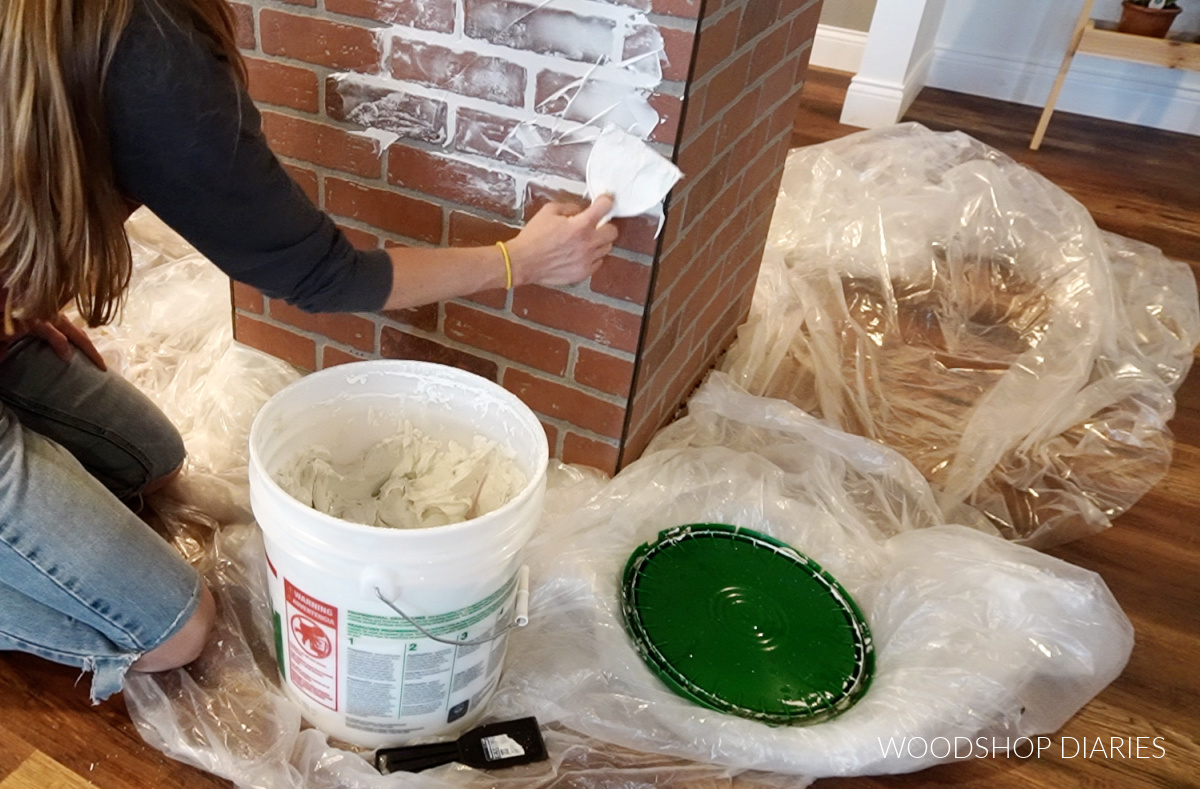 Shara Woodshop Diaries smearing drywall mud onto faux brick panels