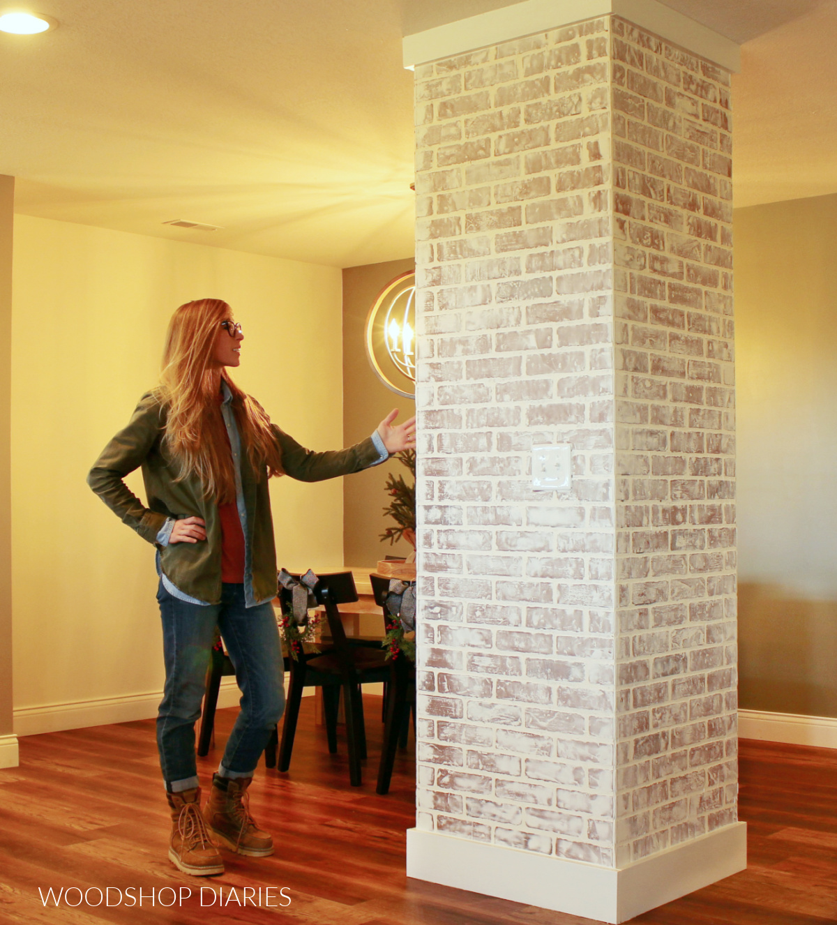 Shara standing next to faux brick column room divider