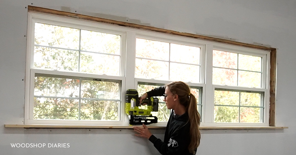 Shara using 16 gauge Ryobi AirStrike to secure window sill in place on window trim