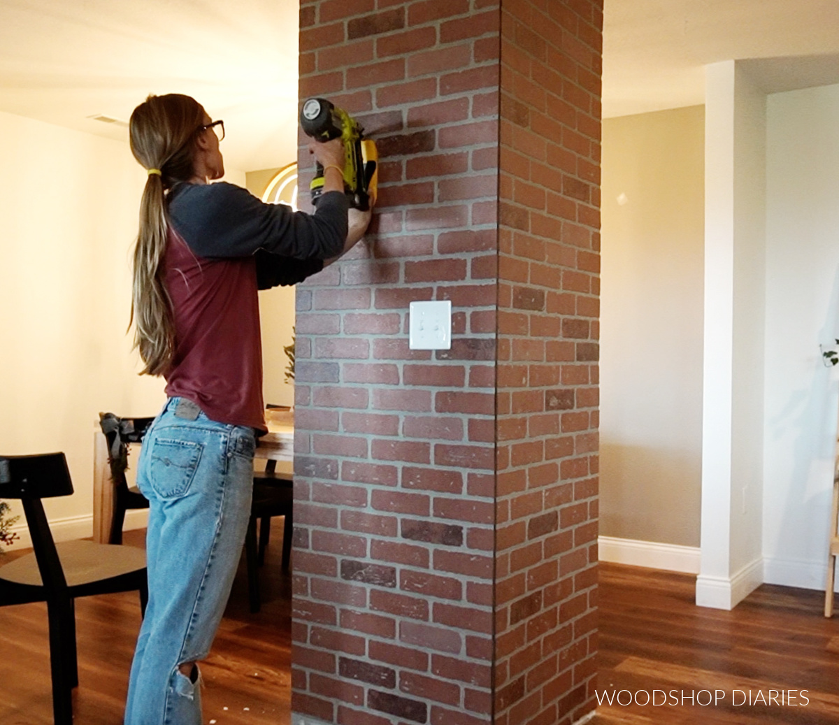 Shara Woodshop Diaries using stud finder to nail brick paneling in place on outside of column