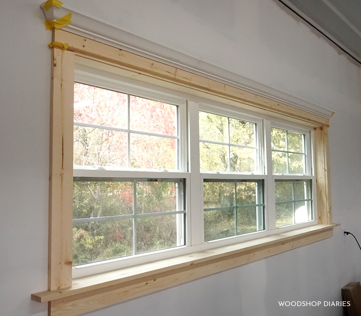 Unfinished DIY window trim installed on workshop window ready for paint
