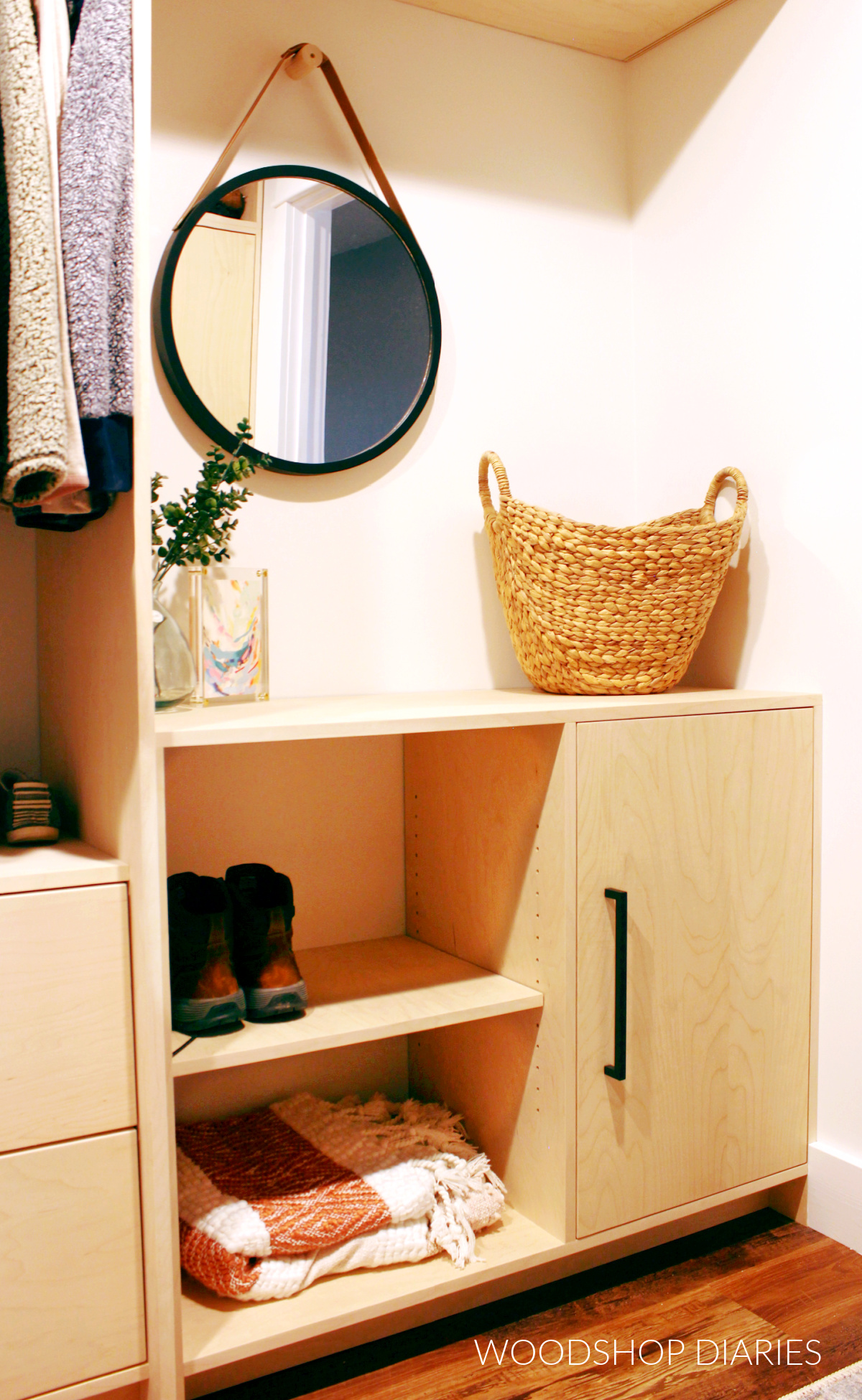 Custom built in dresser cabinet in walk in closet with round mirror above